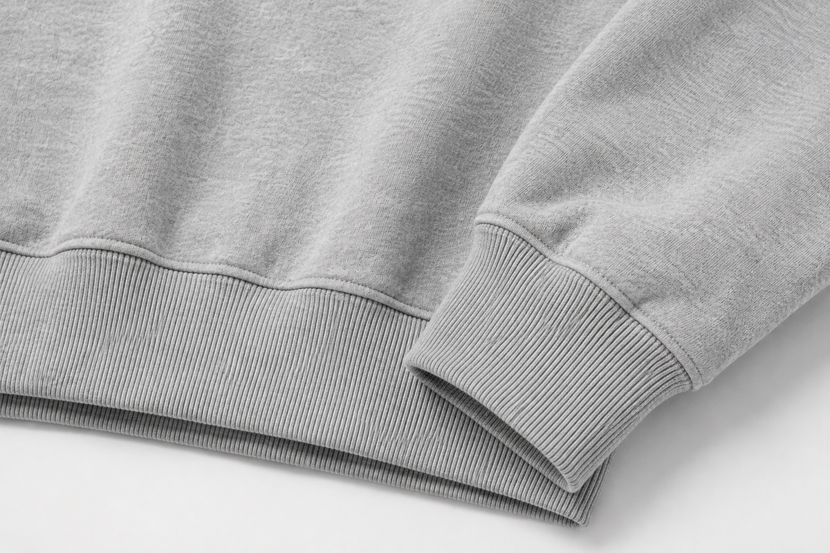 Détail des poignets et de l’ourlet côtelés du sweat-shirt CROWNED BY CHAOS gris chiné