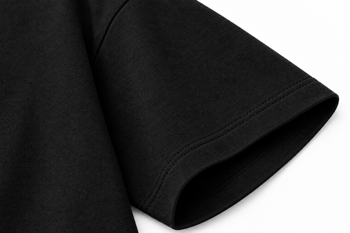 Détail du tissu épais et de la finition de manche du T-shirt CROWNED BY CHAOS noir