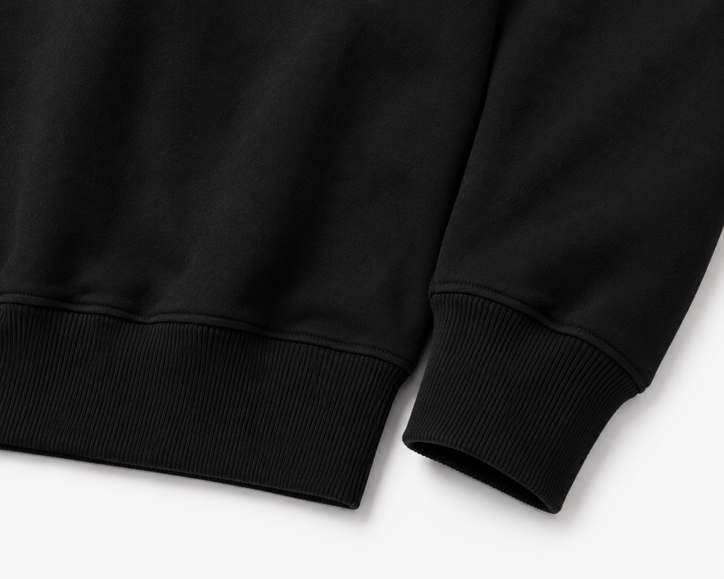 Détail des poignets et de l’ourlet côtelés du sweat-shirt CROWNED BY CHAOS noir