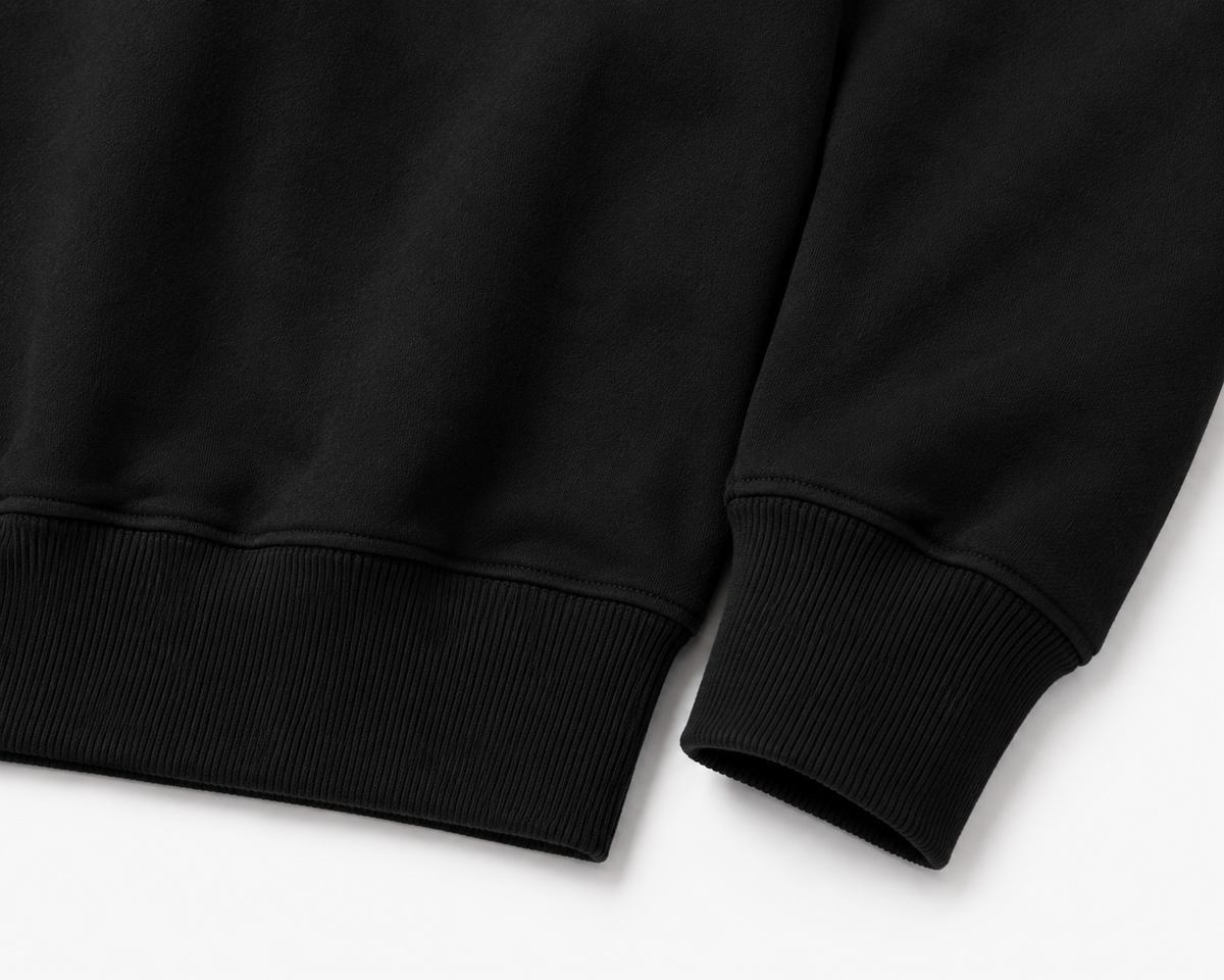 Détail des poignets et de l’ourlet côtelés du sweat-shirt CROWNED BY CHAOS noir